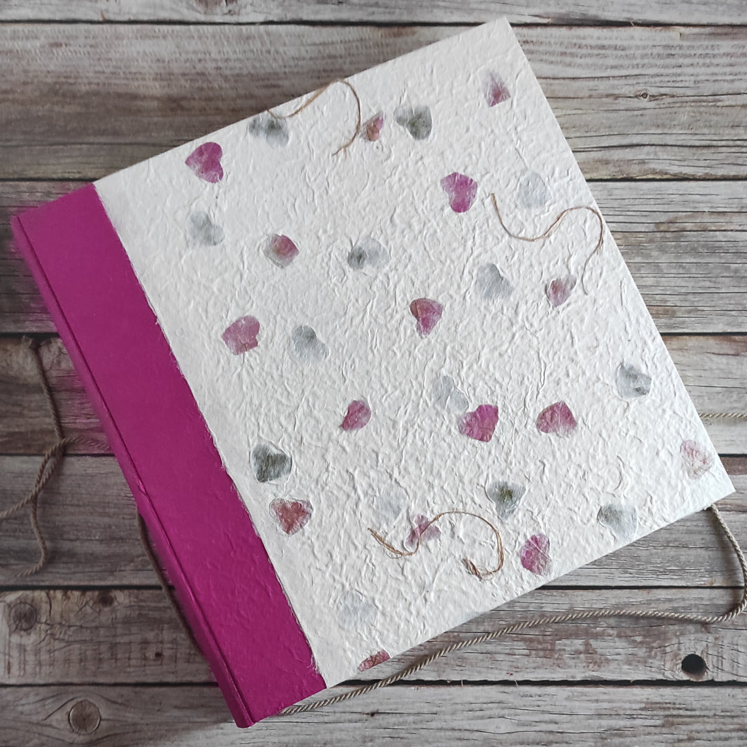 Album fotografico artigianale con copertina in carta di gelso inserti petali colorati pastello abbinata a carta di Gelso tinta unita colore fucsia