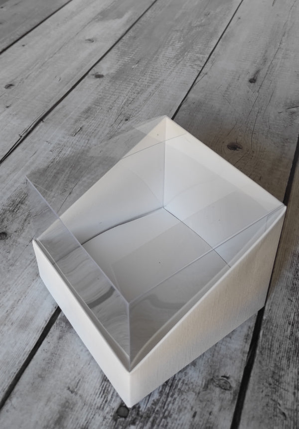 Scatole Vetrina: PVC trasparente e cartoncino bianco, ideali per bomboniere e confezioni regalo. Misura: 12 x 12 x H 11,5 cm