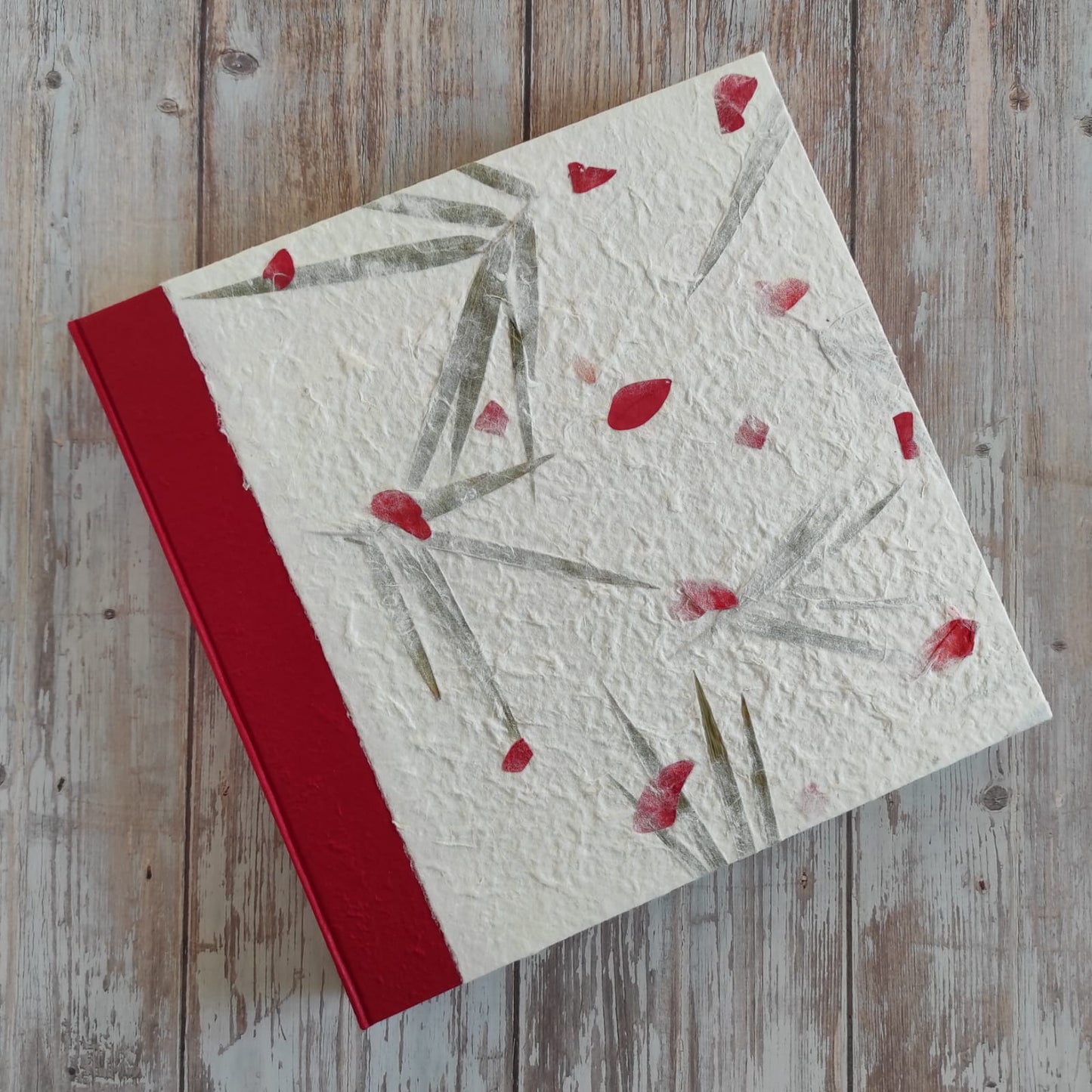 Copertina album fotografico artigianale in carta di gelso petali rossi e foglie grande formato con bordo deckle edge.
