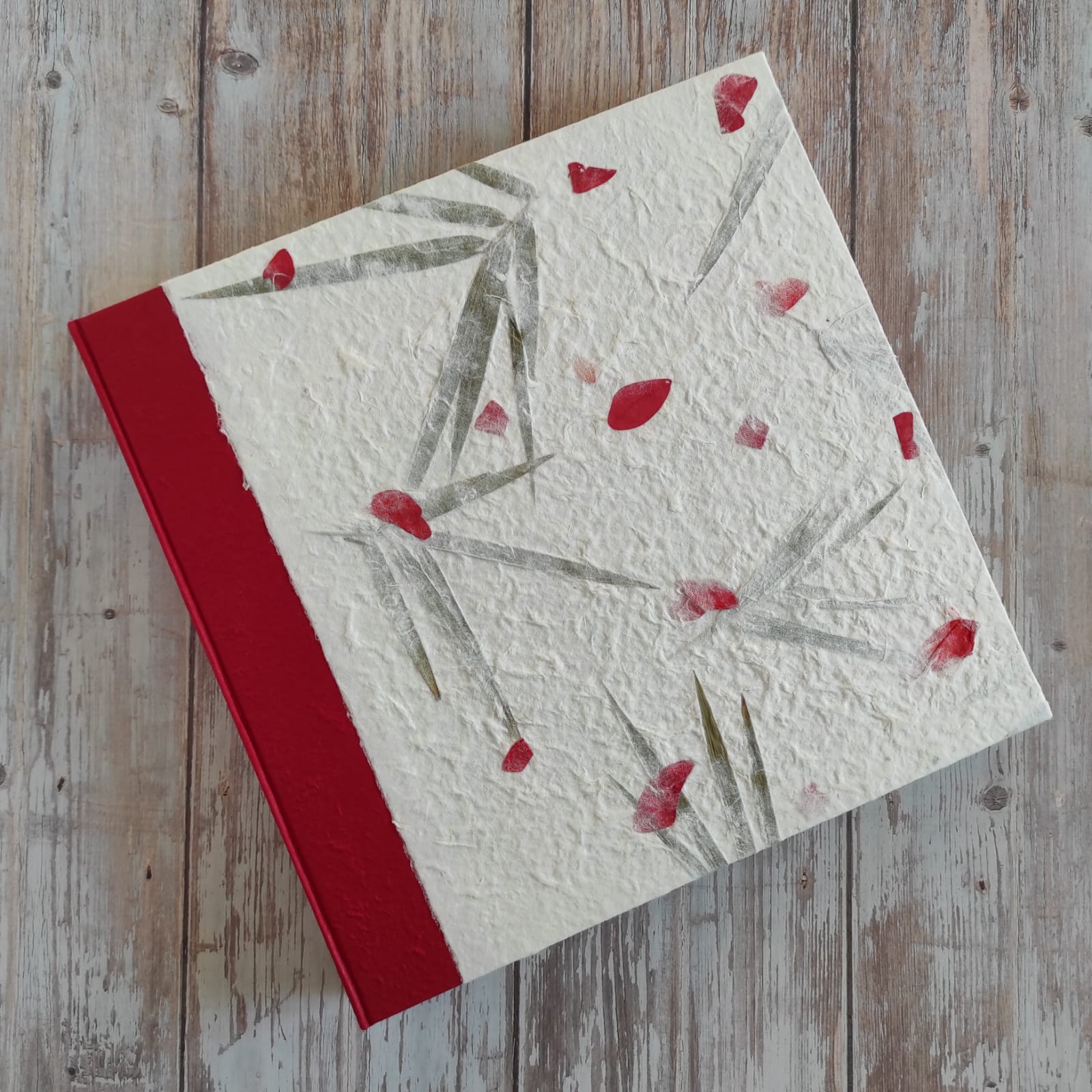 Copertina album fotografico artigianale in carta di gelso petali rossi e foglie grande formato con bordo deckle edge.