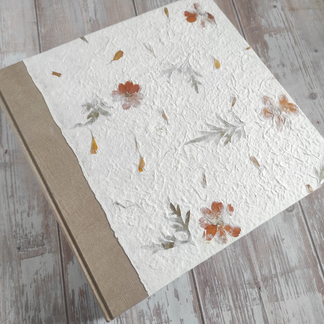 Album fotografico artigianale con copertina a due colori in carta di gelso con fiori arancioni e foglie abbinata a carta Lokta Wax Cotton color terra