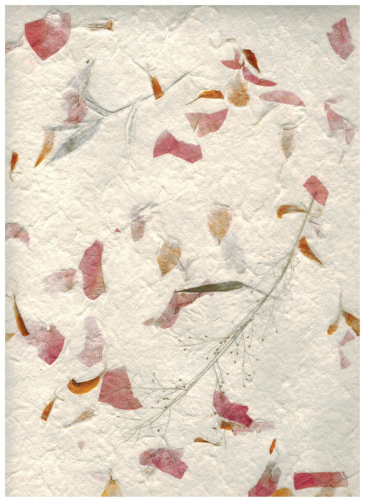 Carta di gelso artigianale con piccoli petali gialli e rosa su fondo bianco latte-avorio