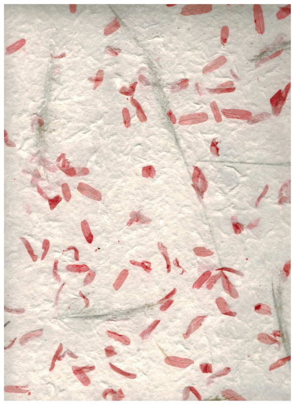 Carta di gelso artigianale con piccoli petali fucsia su fondo bianco latte-avorio