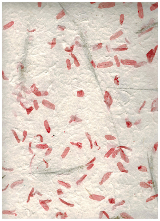Carta di gelso artigianale con piccoli petali fucsia su fondo bianco latte-avorio