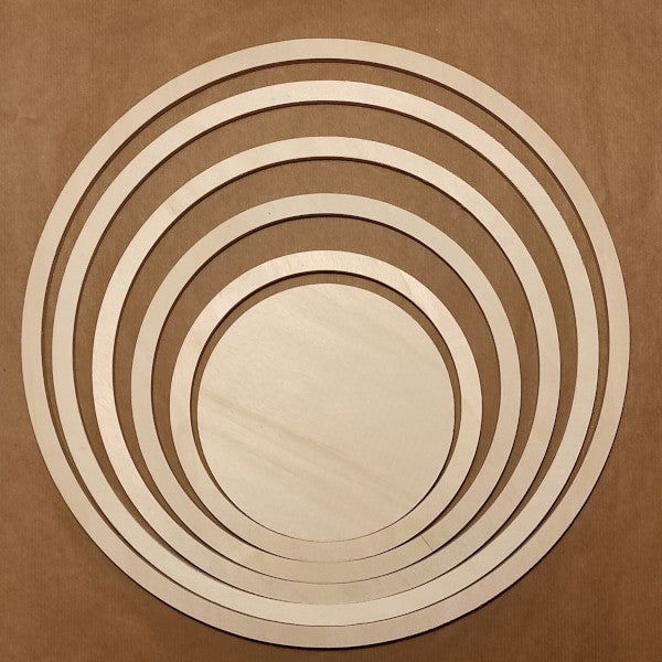Set 6 pezzi in legno naturale grezzo, spessore 0,95 mm, composto da un tondo Ø 16 cm e 5 anelli (larghi 1,3 cm) a diametro crescente: 20 cm, 25 cm, 30 cm, 35 cm e 39 cm.
